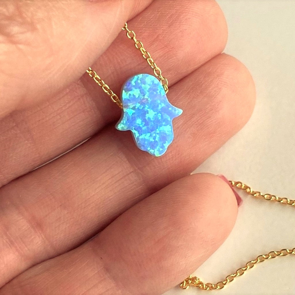 Blue opal hamsa necklace on hand